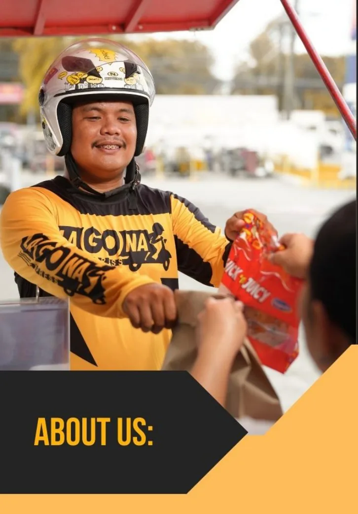 Smiling LaGOna rider in a helmet passing a food order across a store counter